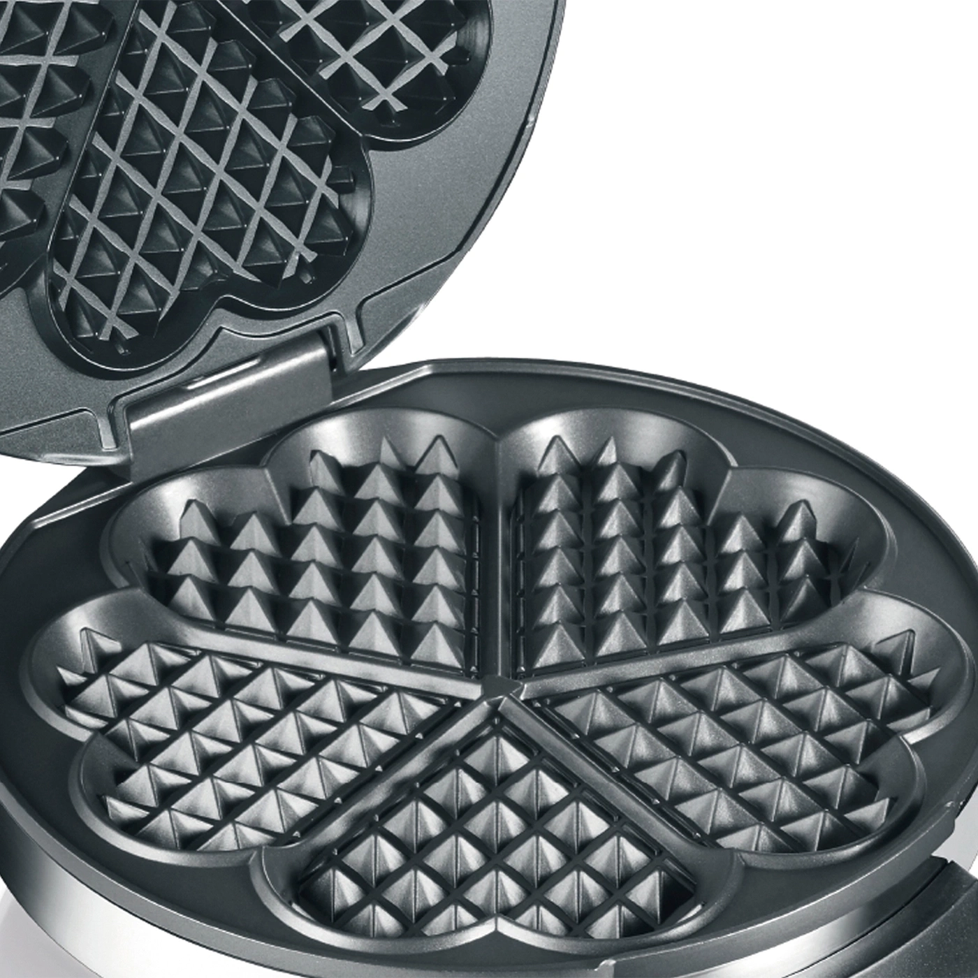 Nahaufnahme eines offenen Waffeleisens mit herzförmigen Vertiefungen