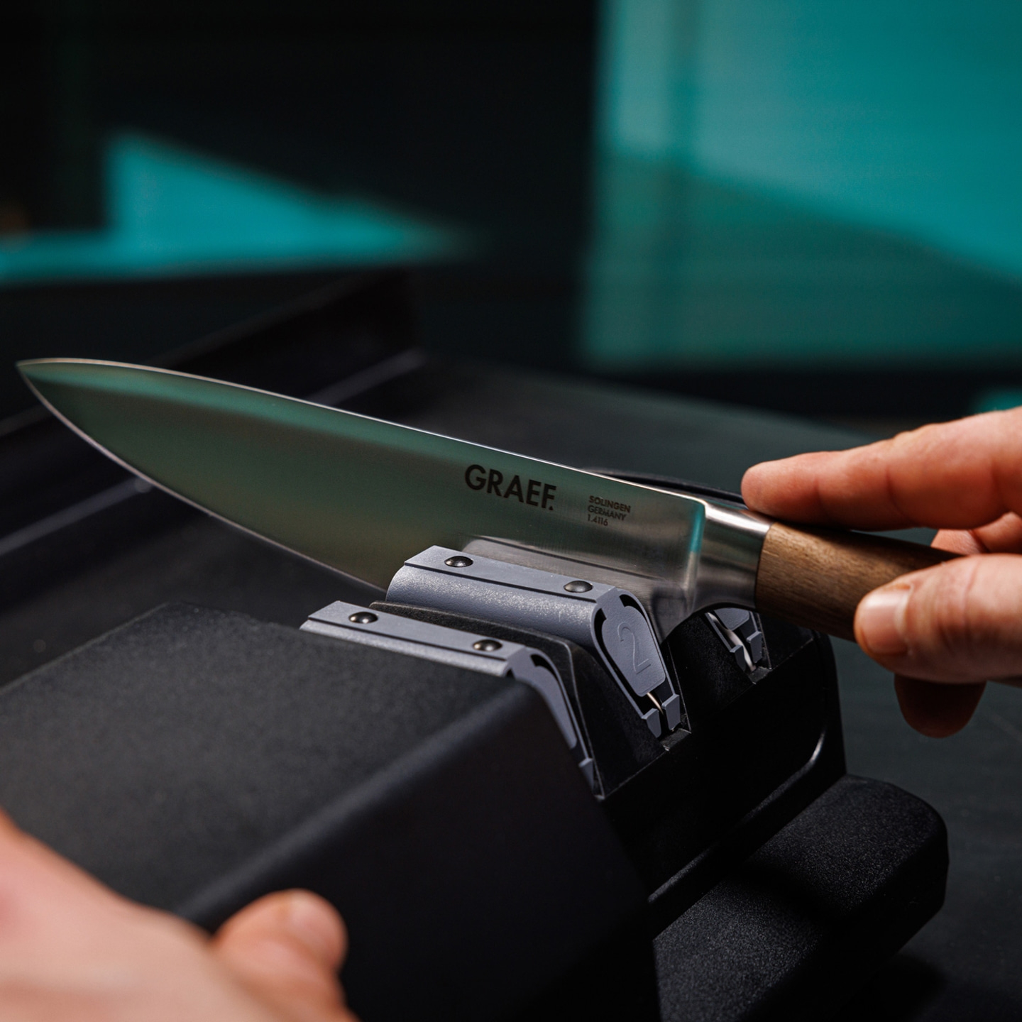 Knife being sharpened. GRAEF knife. Solingen, Germany. Wooden handle. Sharpener. Close-up.