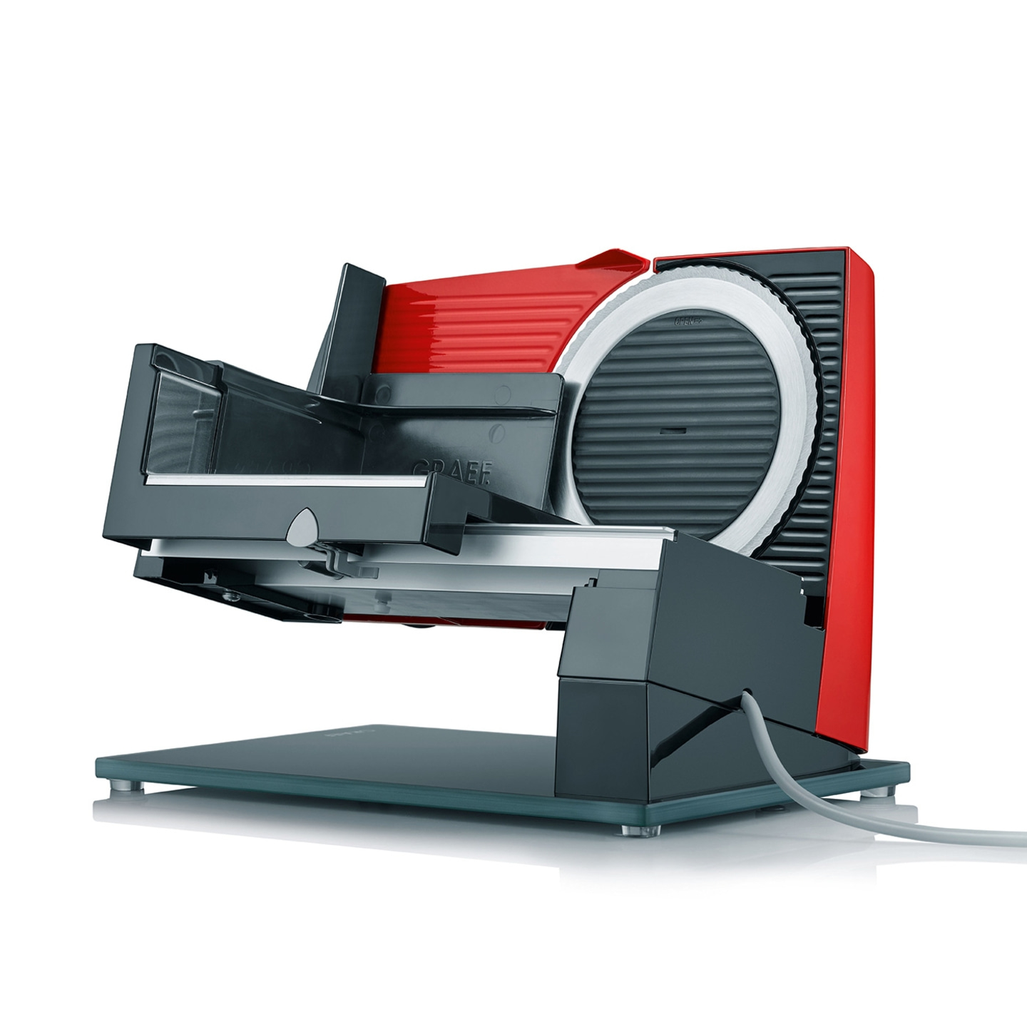 Roter und schwarzer Fleischschneider auf Glasplatte mit Kabel