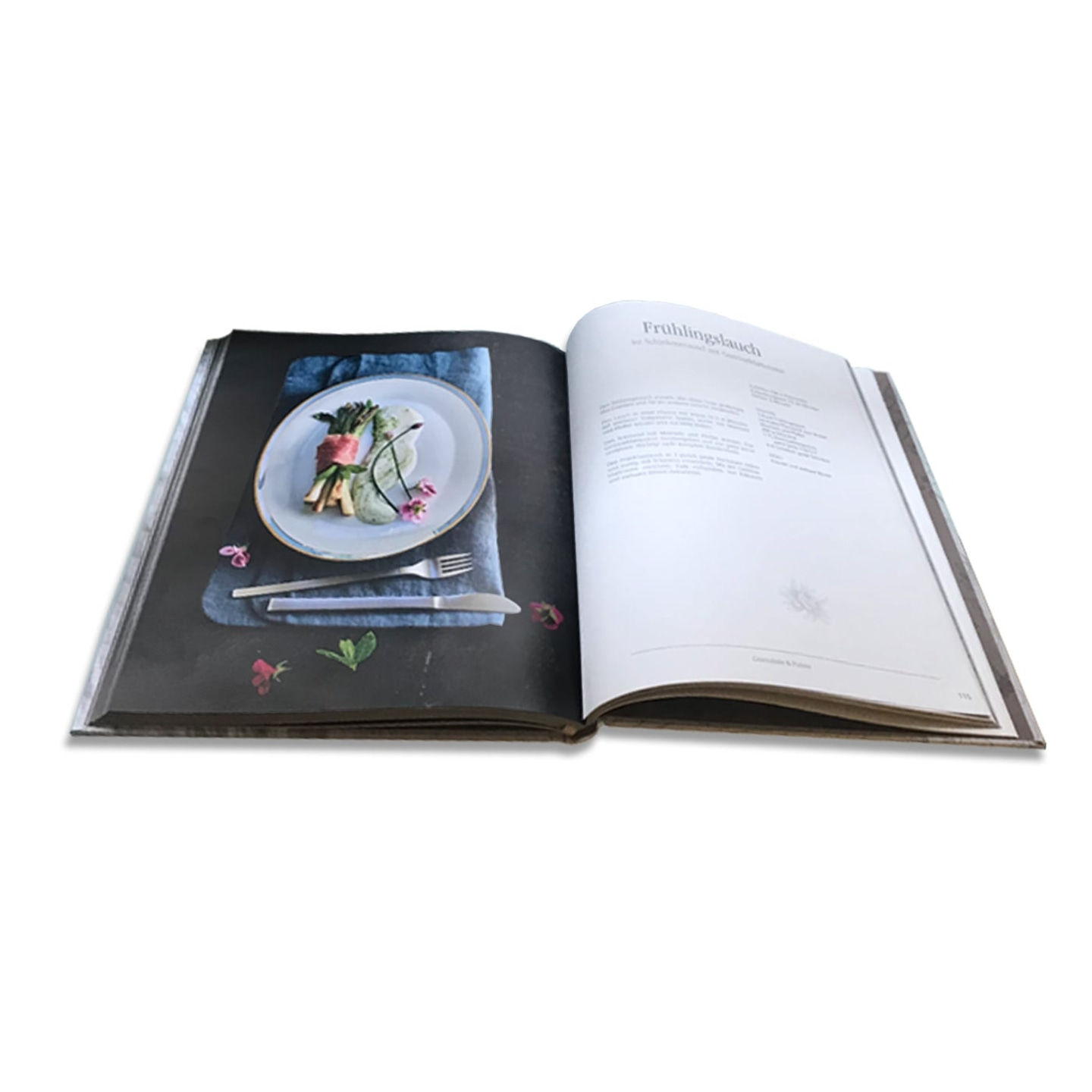Kochbuch mit Frühlingslauch-Rezept und Teller mit Essen