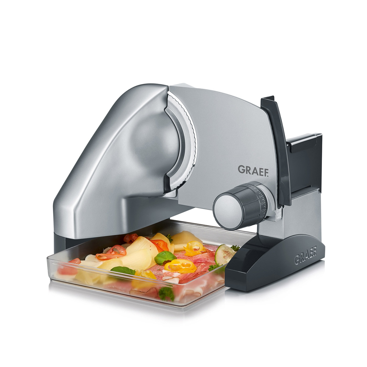 Graef slicer with sliced food in tray. Silver and black machine. Close up.