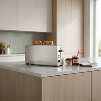 Ein Toaster mit Toast, Marmelade und Beeren auf einer Küchentheke.