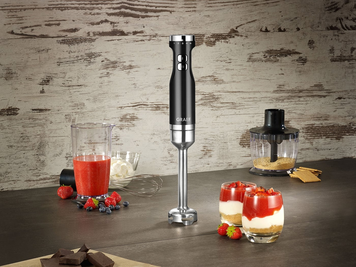 Handmixer mit Zutaten für Dessert, Erdbeeren, Schokolade, Beeren, Gläser