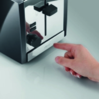 Nahaufnahme eines Toasters mit einer Hand, die auf die Taste drückt.