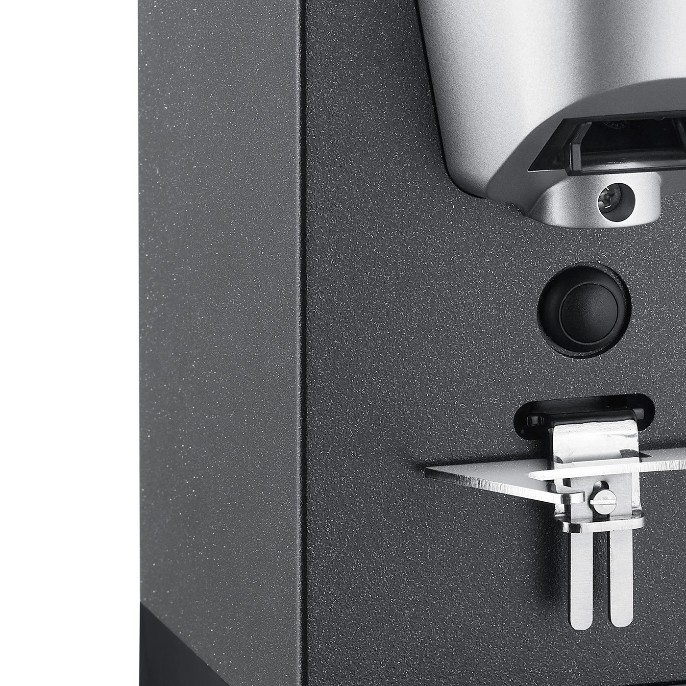 Close-up of a black device with a button and a metal part