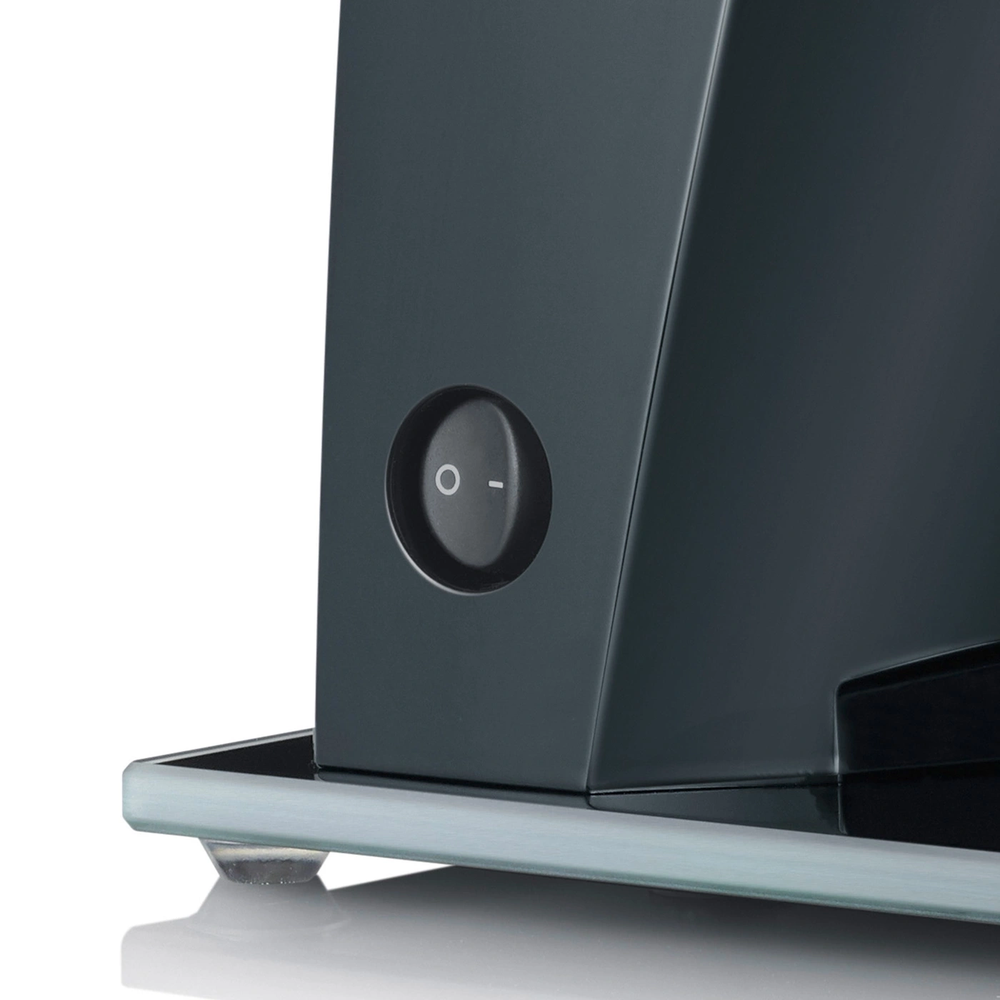 Close-up of a black appliance with an on-off switch on a glass plate, isolated