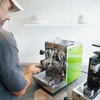 Mann bereitet Kaffee mit einer Espressomaschine zu.