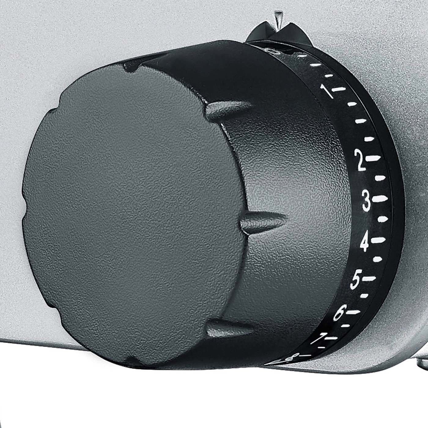 Close-up of a black dial with numbers on a silver background.
