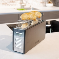 Ein Toaster mit Croissants. Küche. Frühstück. Brot. Gerät. Essen. Backen. Schwarz.